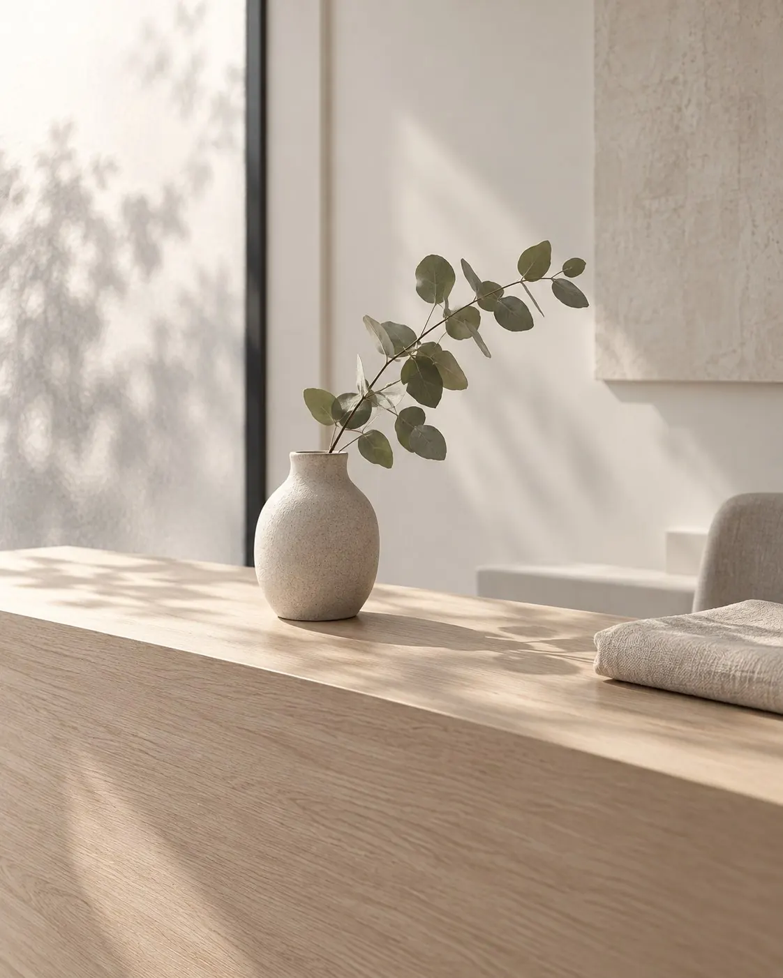 A calm allied health reception counter with a vase of eucalyptus
